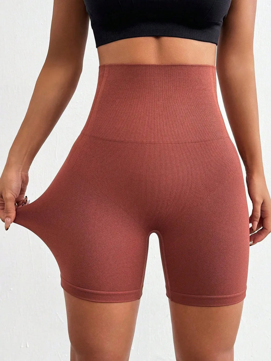 Brown high-waisted shorts worn by a person on a white background