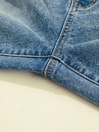 Close-up of blue denim fabric on a beige surface