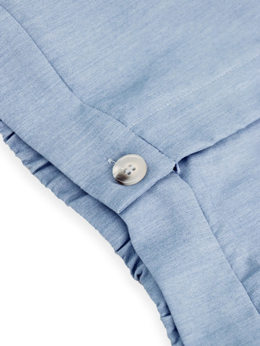 Close-up of a blue fabric with a button on a white background