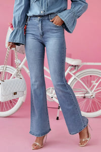 Person wearing blue jeans and a denim shirt with a white bicycle in the background.