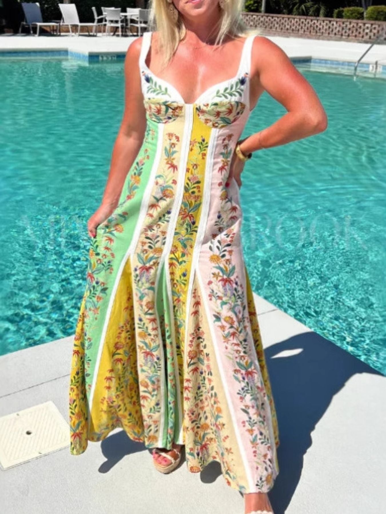 Woman in a floral dress standing by a pool