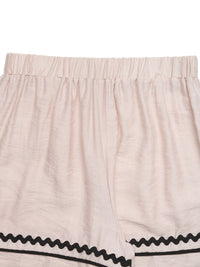 Beige shorts with black trim on a white background