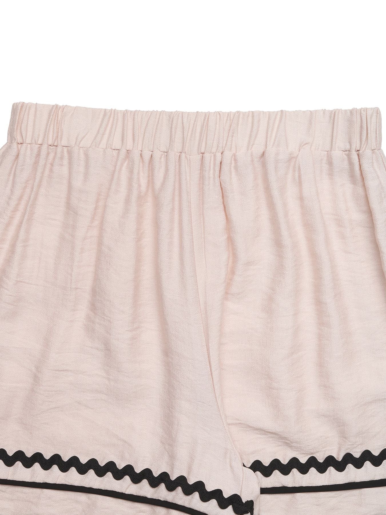 Beige shorts with black trim on a white background