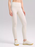 Person wearing white leggings on a plain background