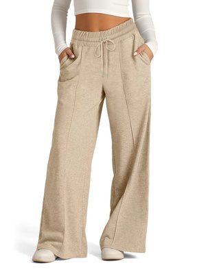 Beige sweatpants worn by a person on a white background