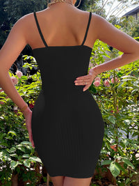 Person wearing a black dress with thin straps in a garden setting