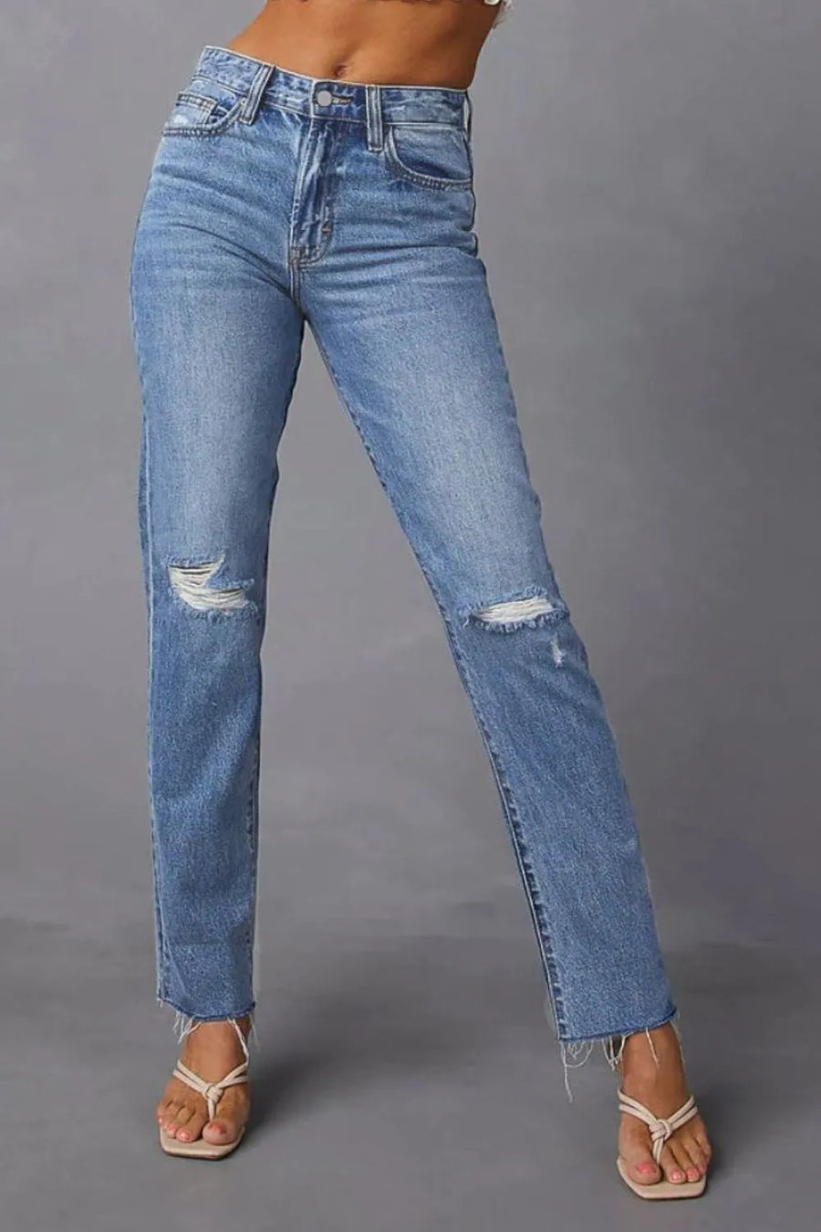 Blue jeans with slight distressing on a gray background