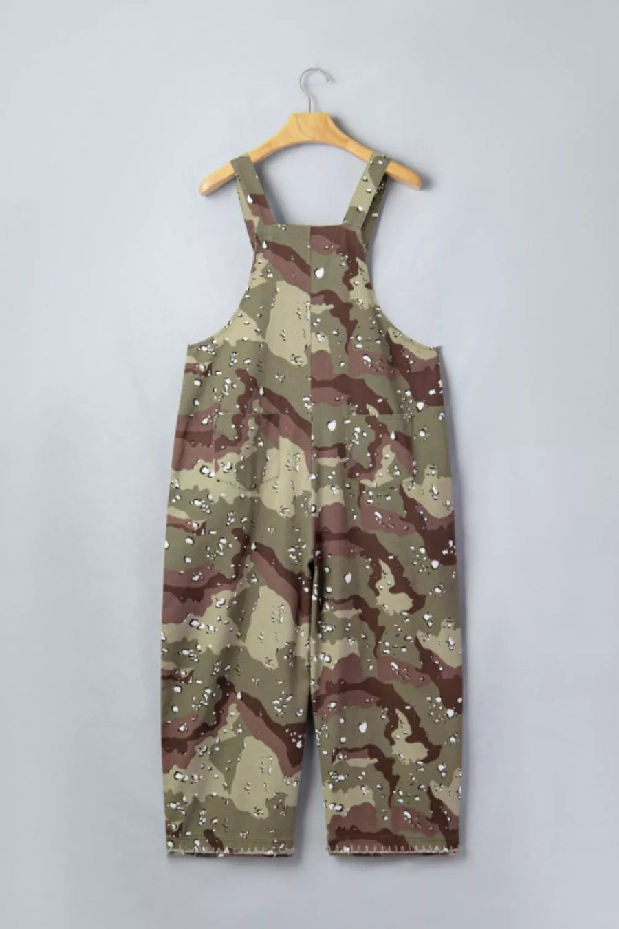 Camouflage overalls on a hanger against a light gray background
