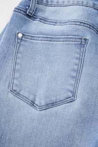 Close-up of a blue denim pocket with a button.