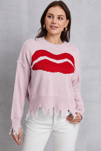 Woman wearing a pink sweater with a red and white design on a gray background