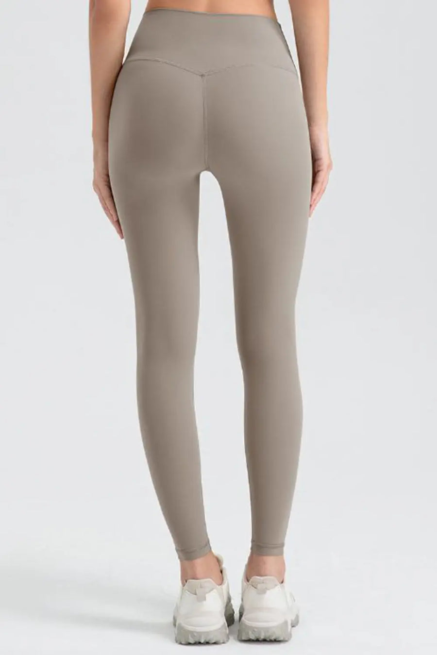 Person wearing beige leggings on a white background