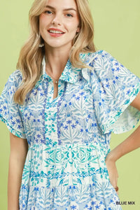 Woman wearing a blue and white patterned dress against a light green background