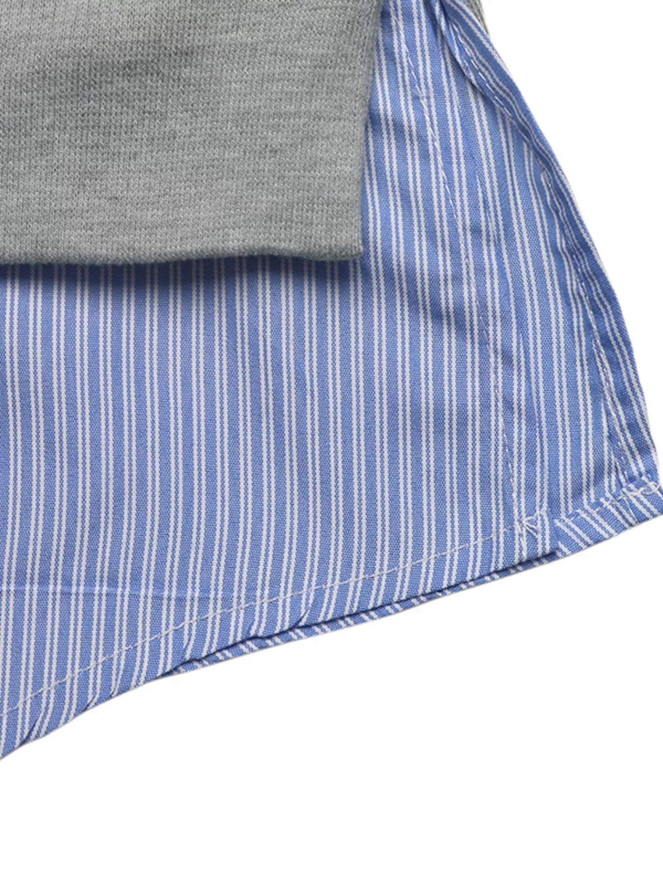 Close-up of a folded gray shirt and blue striped fabric on a white background