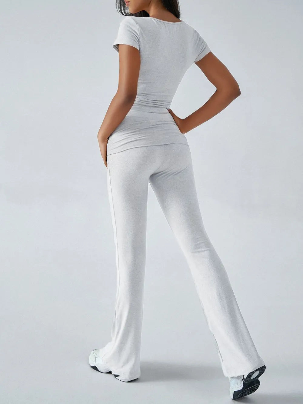 Person wearing a white outfit with a plain background