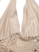 Beige bikini top with lace details on a white background