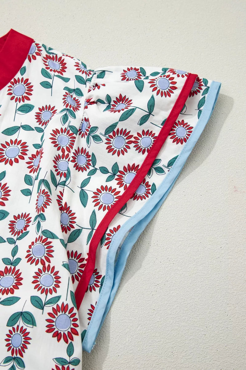 Floral-patterned fabric with red and blue accents on a beige surface