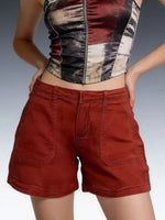 Person wearing a patterned top and red shorts on a gradient background