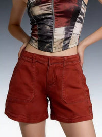 Person wearing a patterned top and red shorts on a gradient background