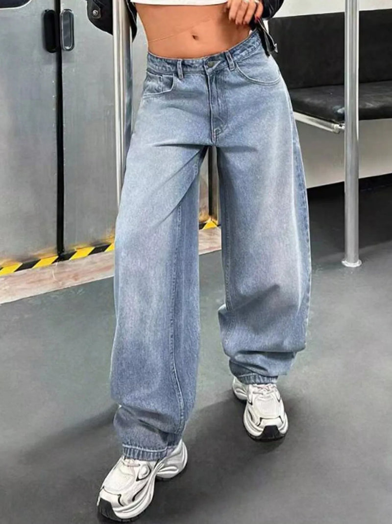 Person wearing blue jeans and white sneakers in an indoor setting