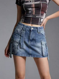 Person wearing a blue denim skirt and a patterned top on a gray background