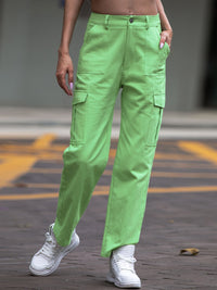 Person wearing bright green cargo pants and white sneakers on a street.