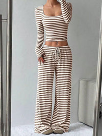 Person wearing a brown and white striped outfit in a minimalistic room.
