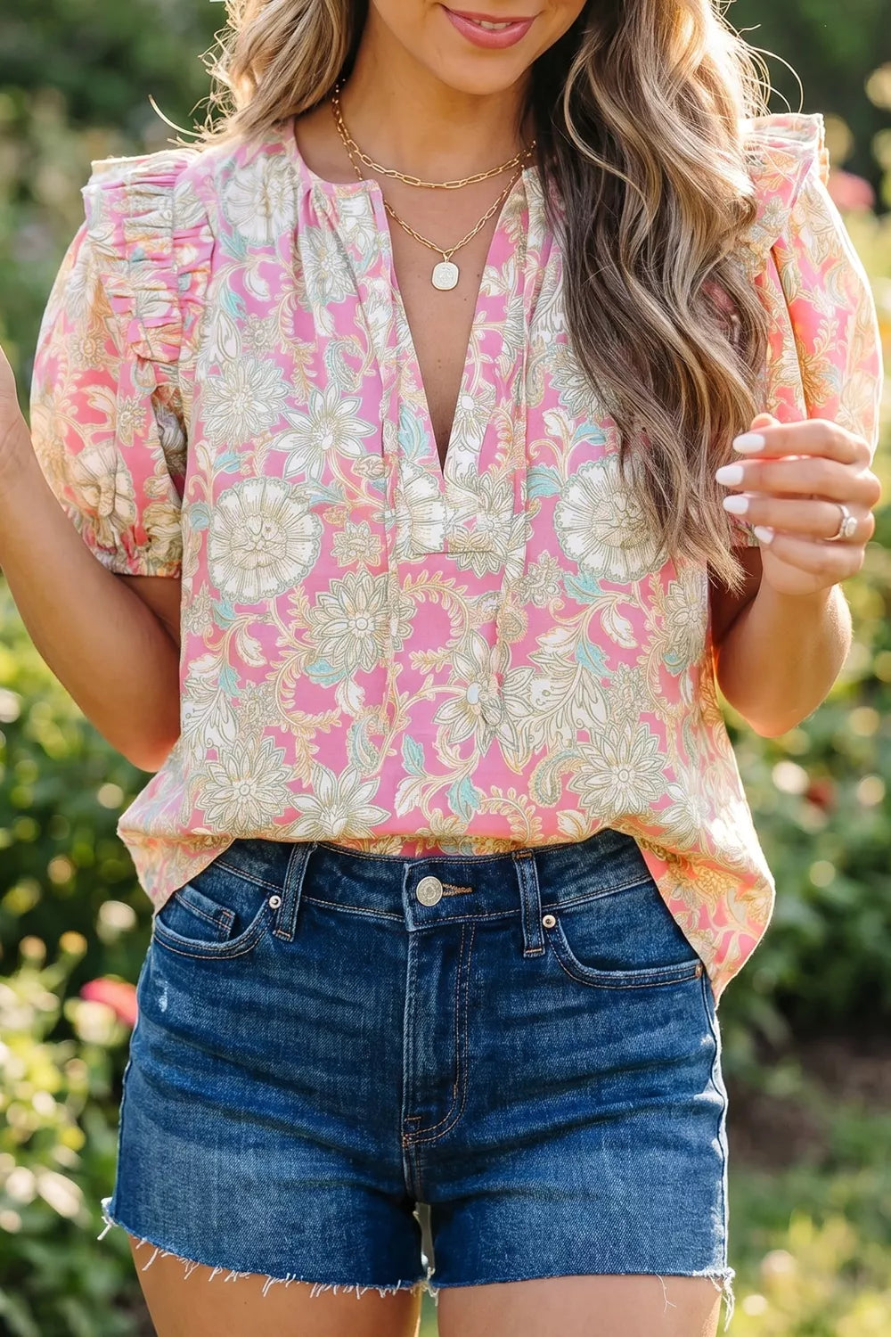 Woman wearing a floral blouse and denim shorts outdoors