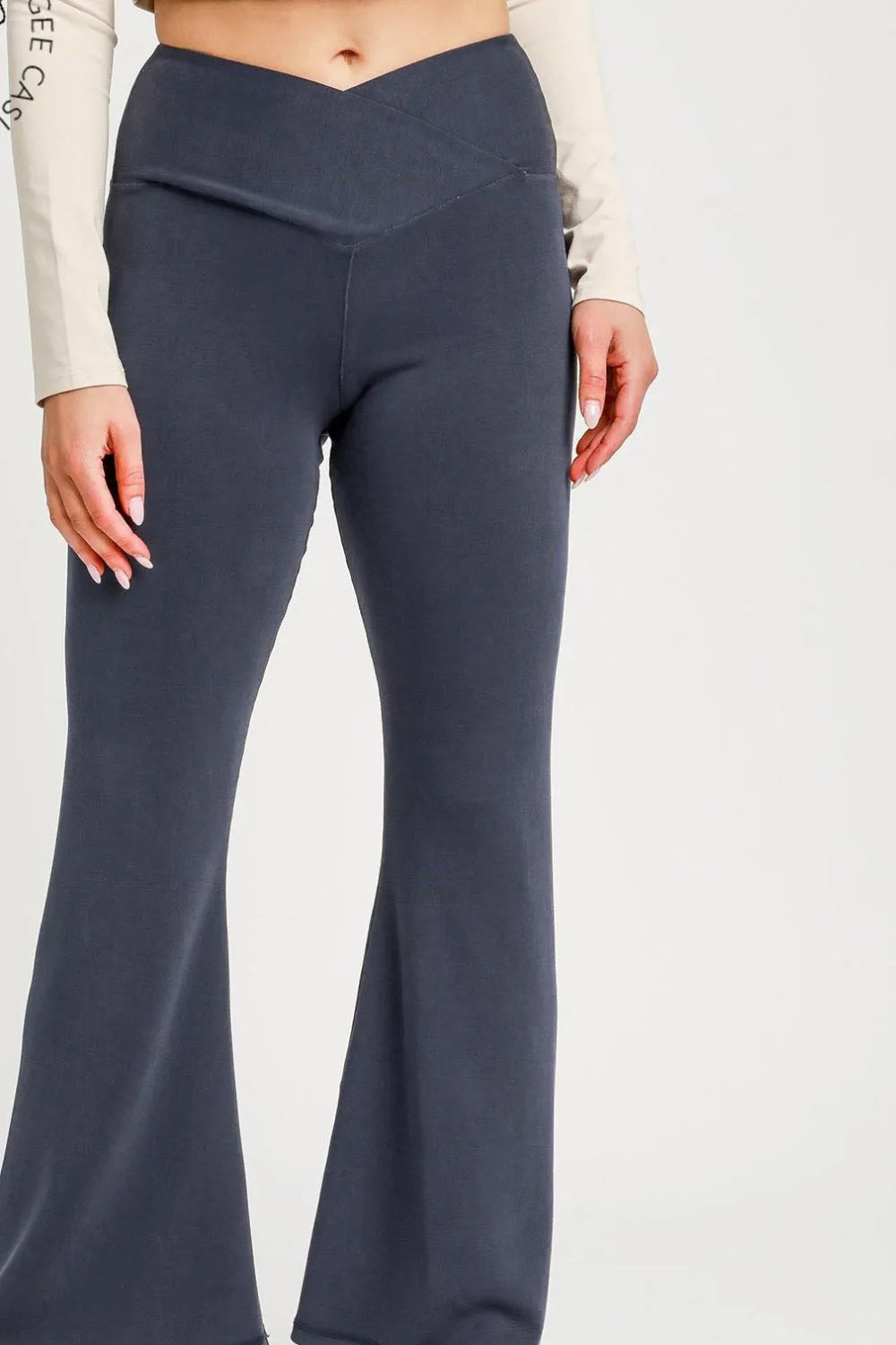 Dark gray flared pants worn by a person on a white background