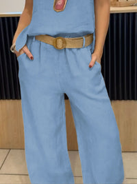 Person wearing a blue jumpsuit with a brown belt in an indoor setting