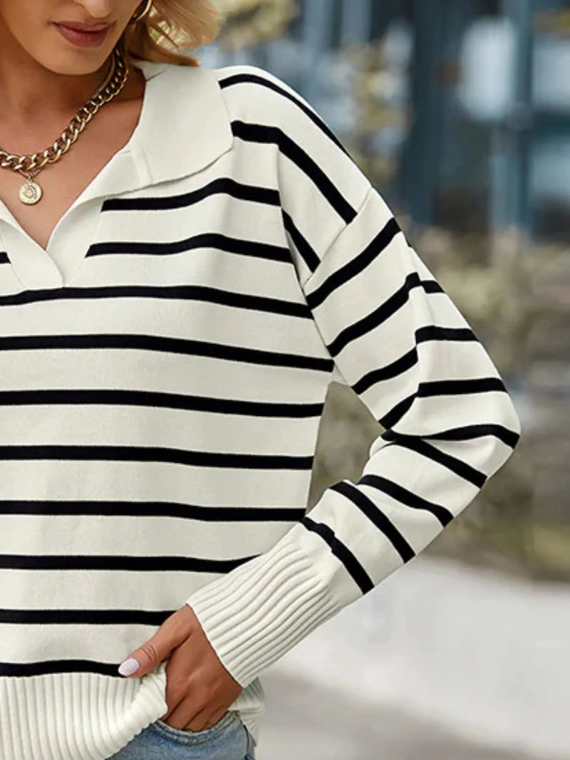 Person wearing a black and white striped sweater with a blurred background