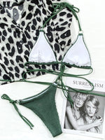 Leopard print bikini top and green string bikini bottom on a magazine with a model photo.