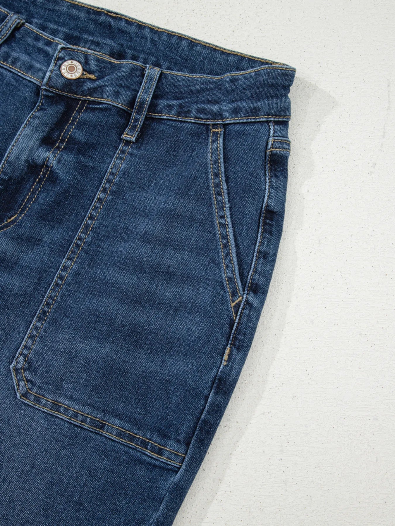 Close-up of blue denim jeans on a white background