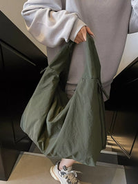 Person holding a green bag indoors