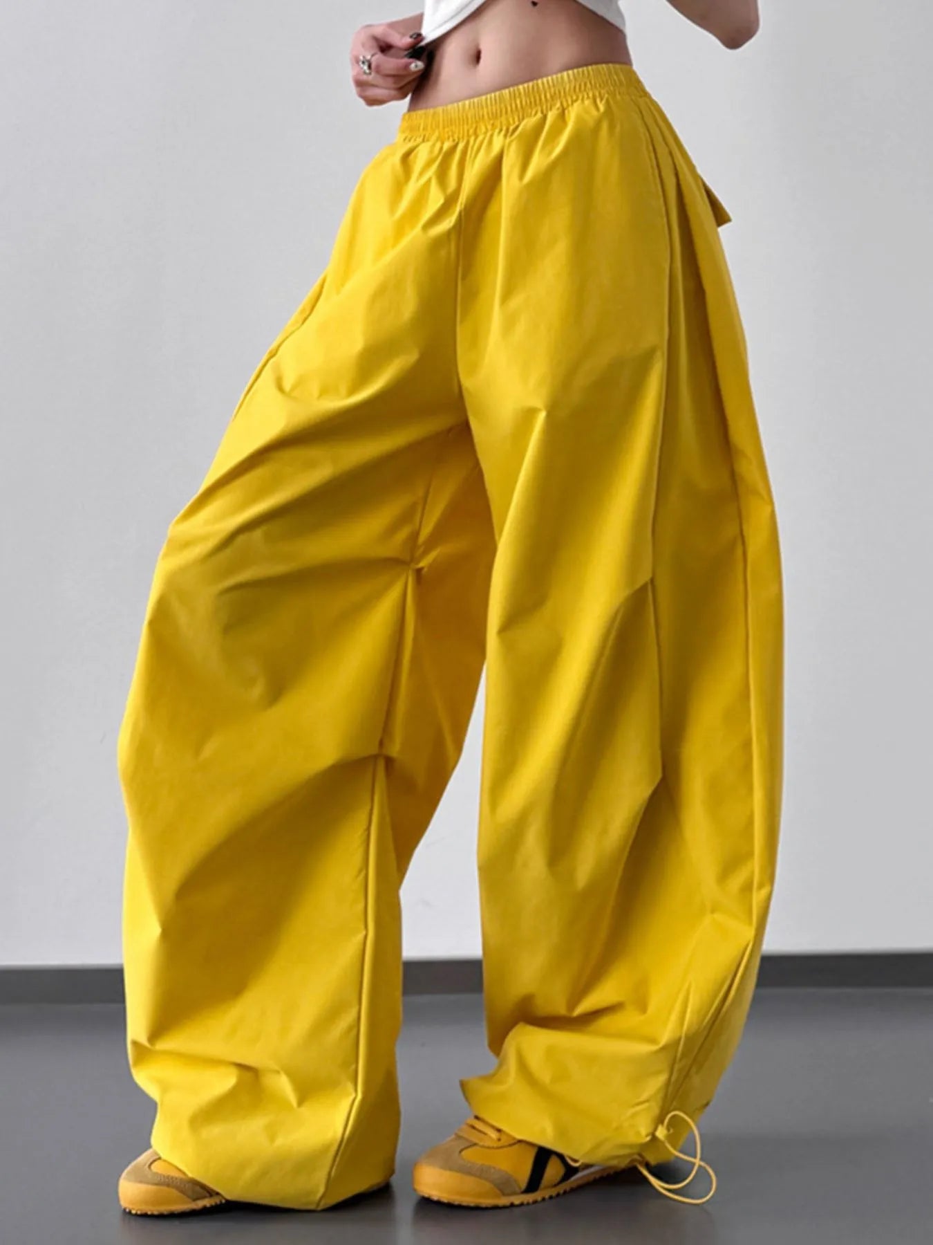 Yellow wide-leg pants worn by a person on a plain background