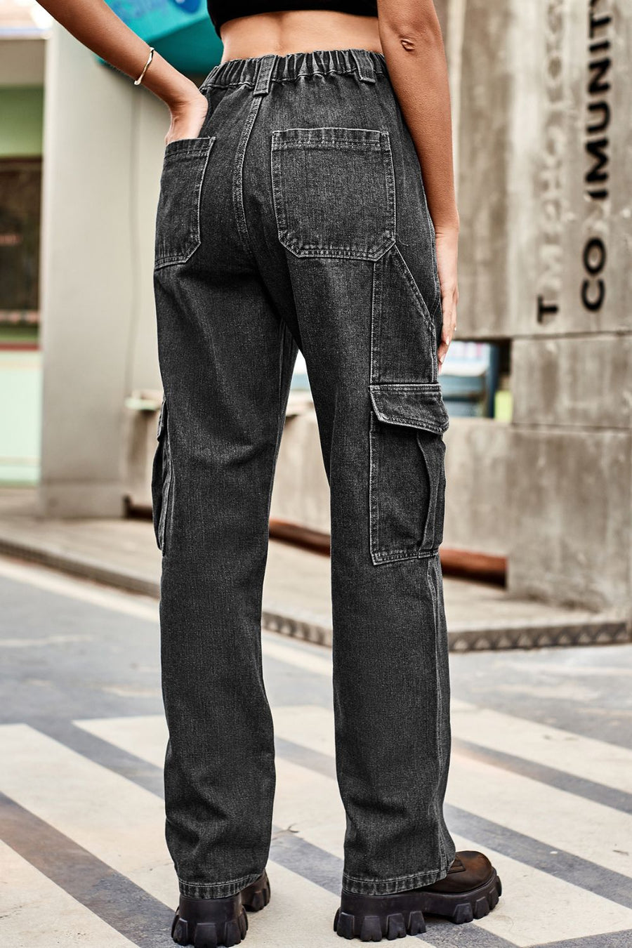 Person wearing black cargo pants on a city street.