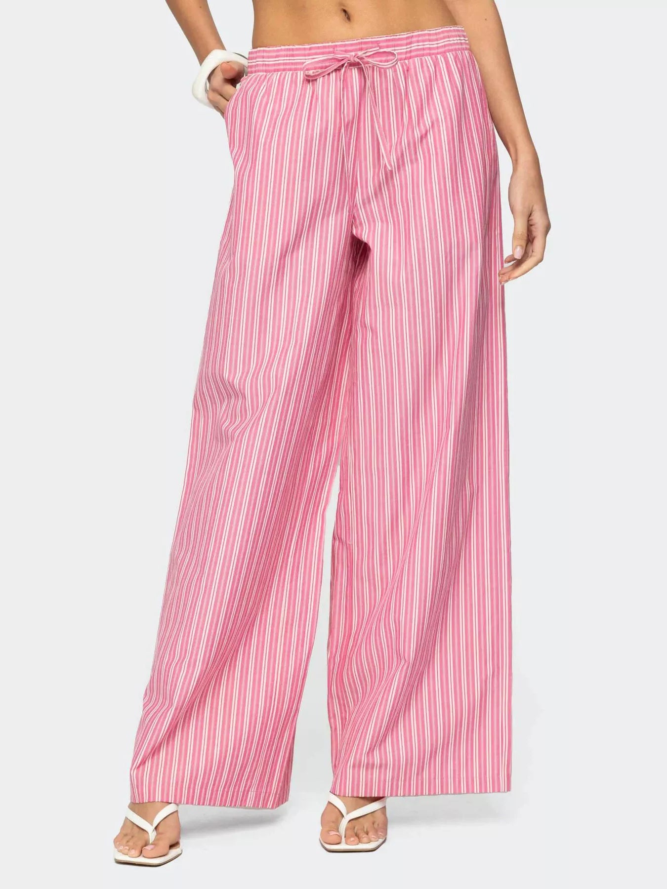 Pink striped pants worn by a person on a white background