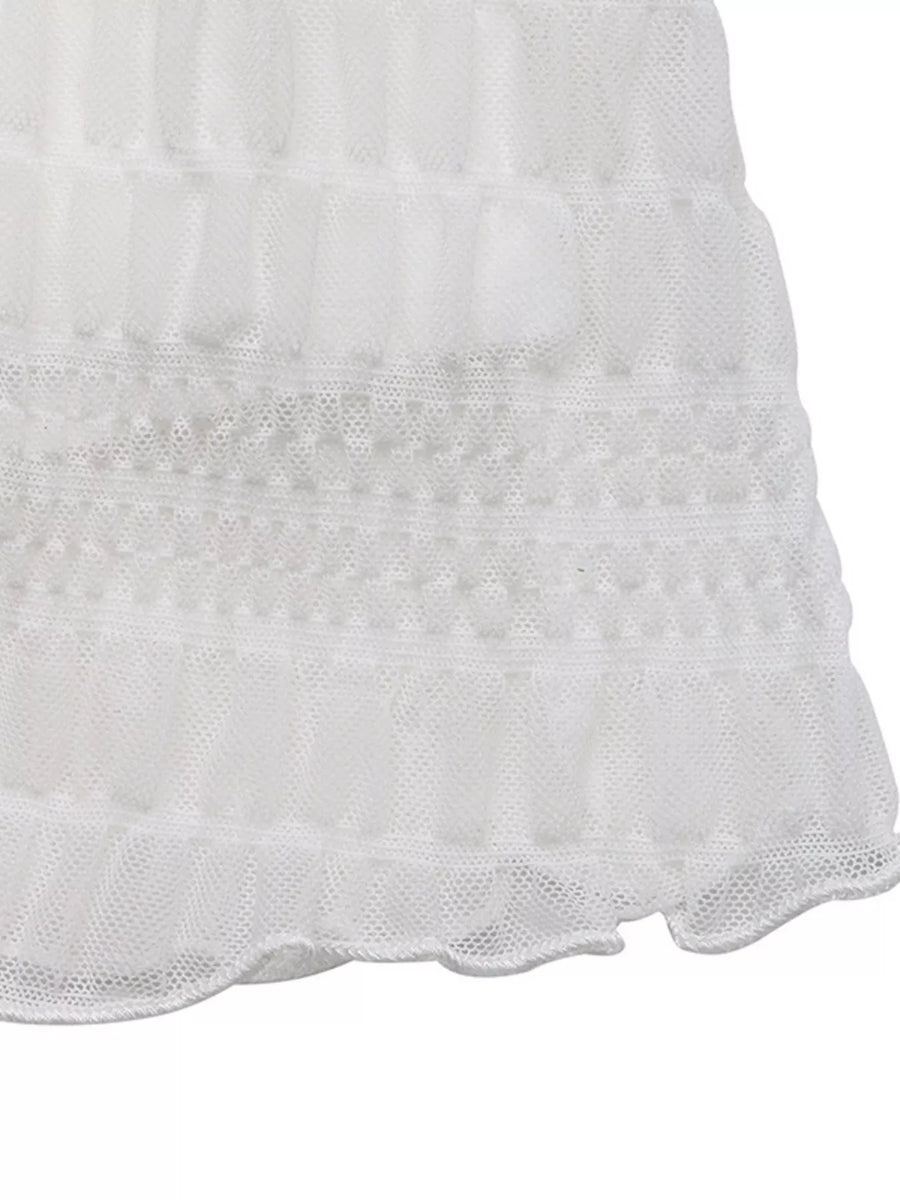Close-up of a white textured fabric with scalloped edge on a white background