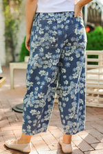 Person wearing blue floral pants standing outdoors on a patio.