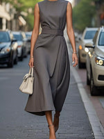 Woman in a gray dress walking on a city street