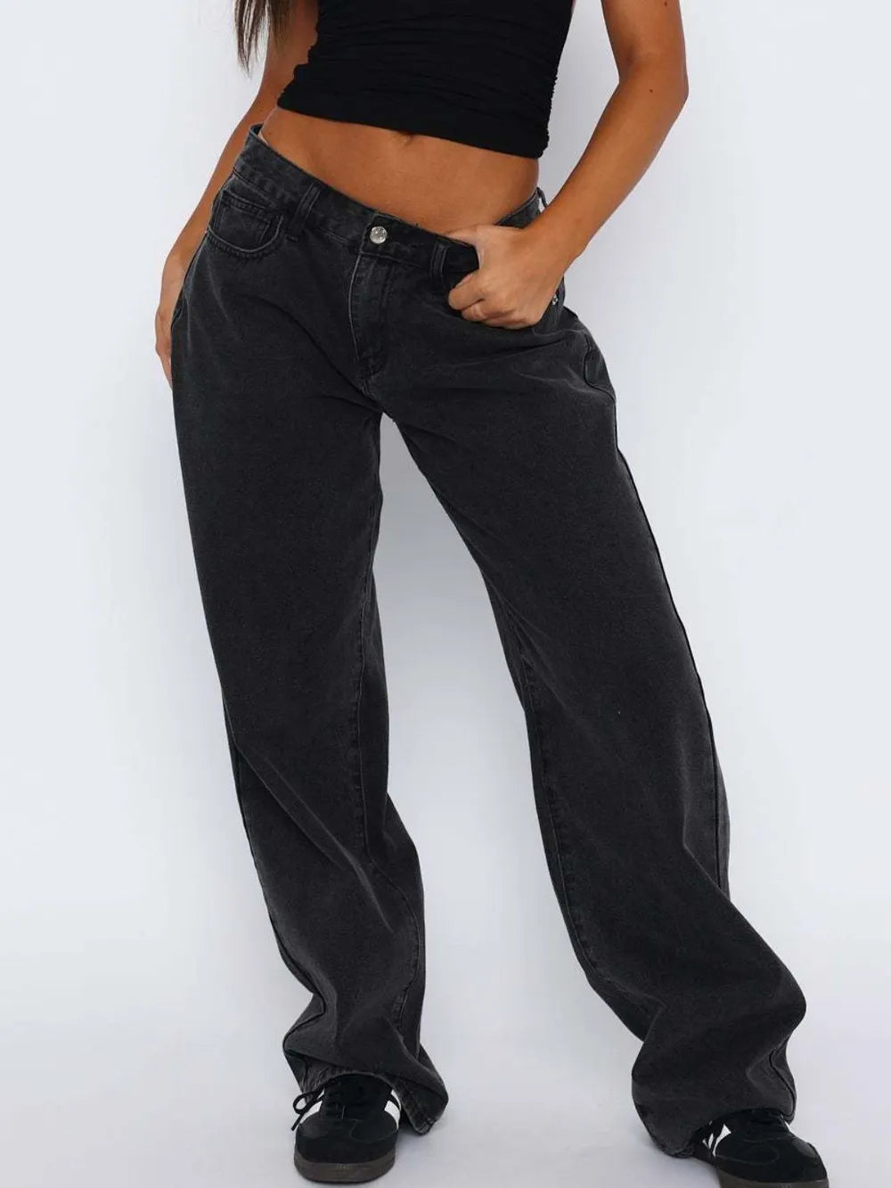 Person wearing black wide-leg jeans and a black top on a white background