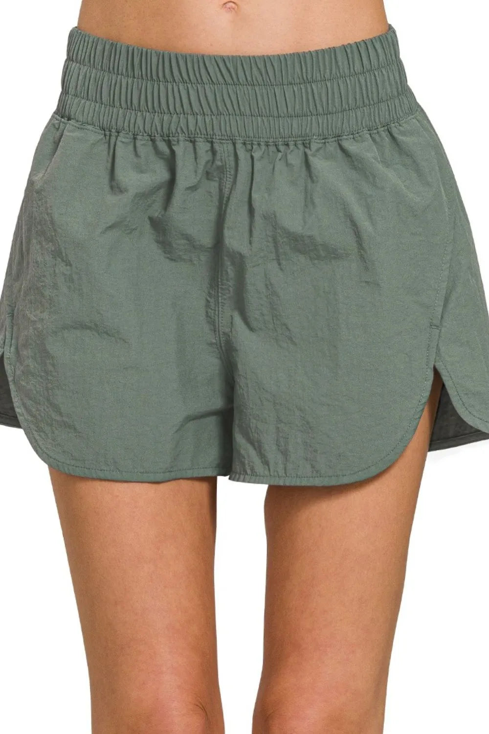 Green shorts worn by a person on a white background