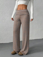 Person wearing brown and white checkered pants against a gray background