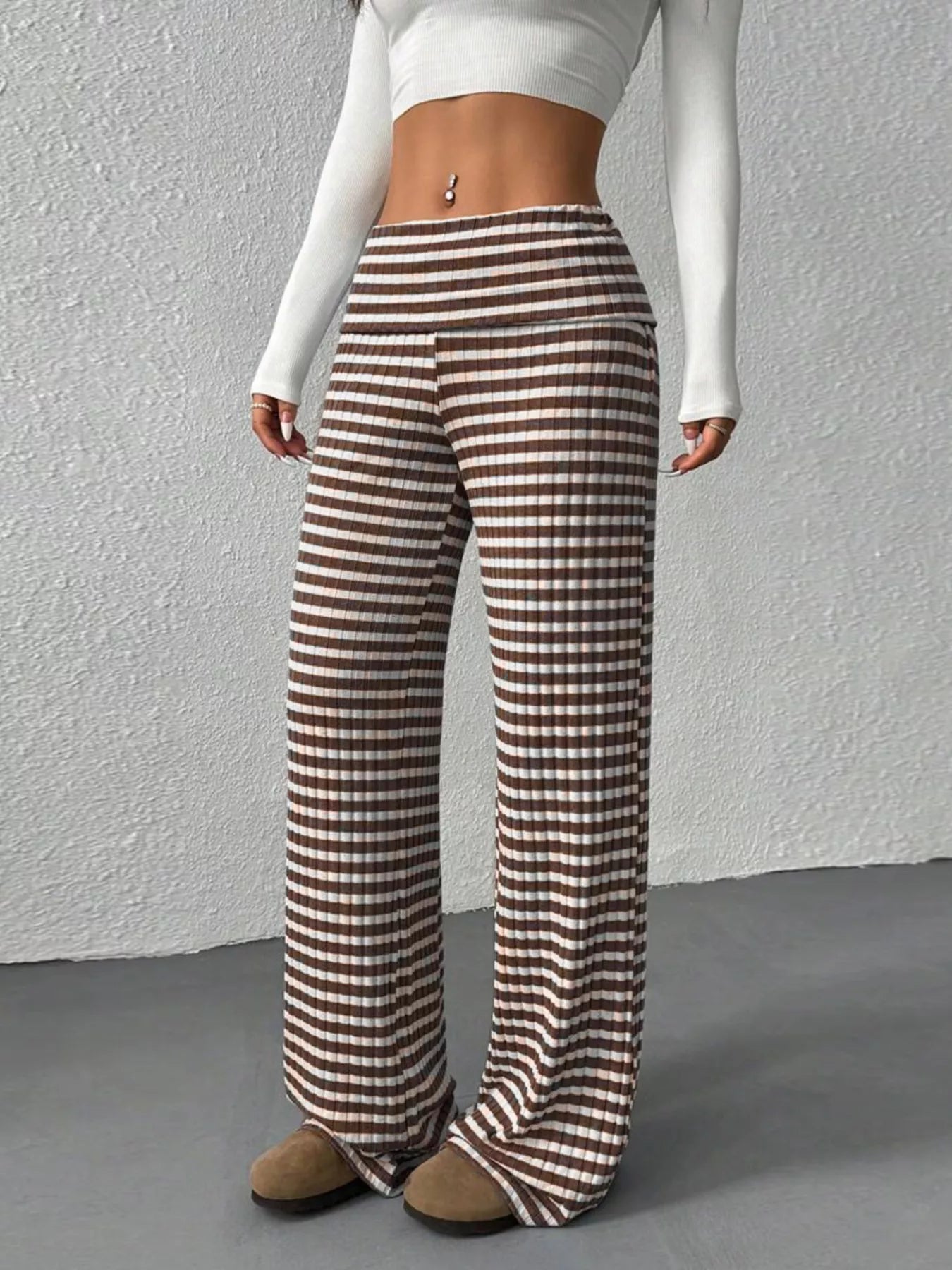 Person wearing brown and white checkered pants against a gray background