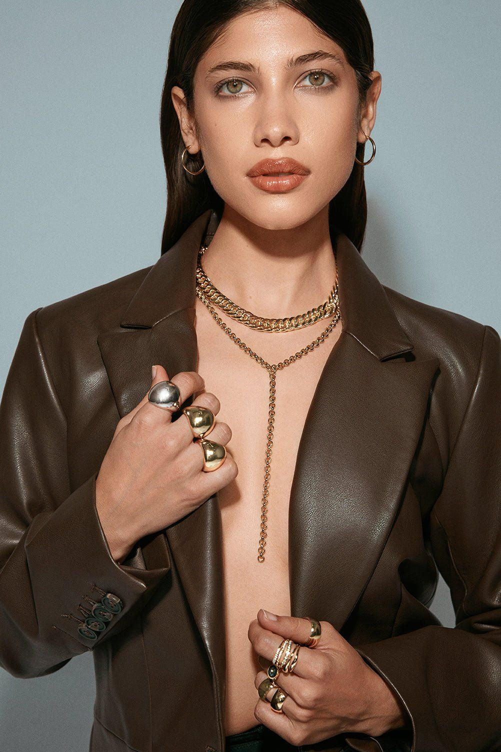 Model with rings on her fingers and leather coat on with Arya Necklace around her neck