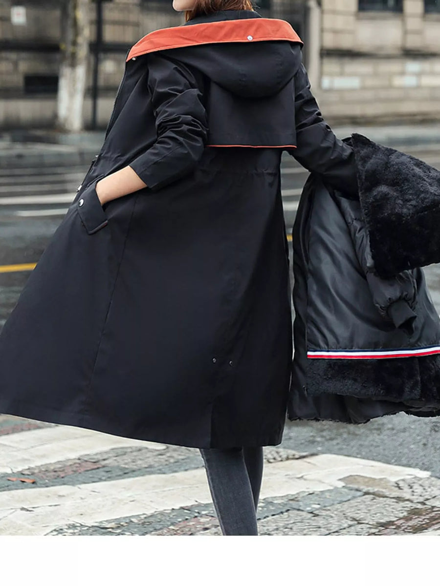 Lady showing the back of black Women's Detachable Longline Hooded Parka with Faux Fur Trim and Drawstring Waist with the lining in her hand