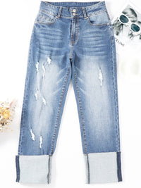 Distressed blue jeans on a white background