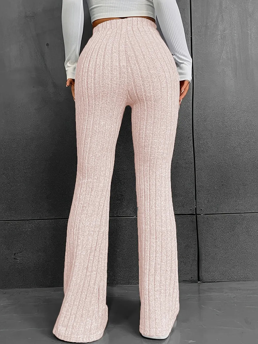 Person wearing light pink ribbed knit pants against a gray background