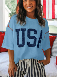 Person wearing a blue 'USA' shirt in a casual setting