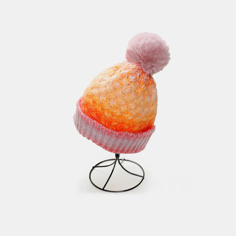 Colorful knit beanie with a pom-pom on a white background