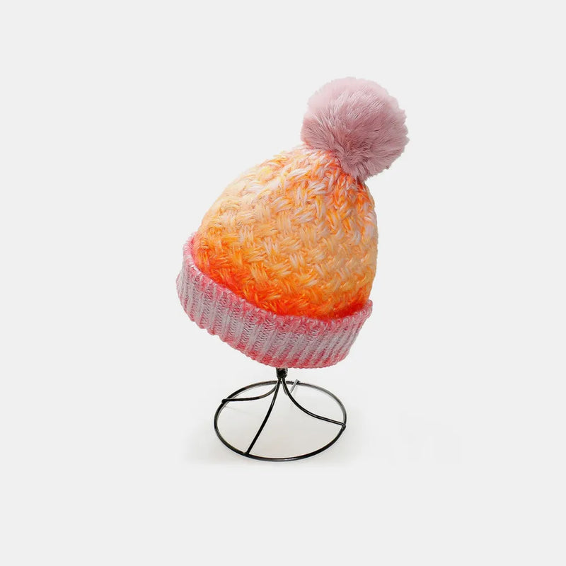 Colorful knit beanie with a pom-pom on a white background